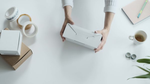woman using self folding white ecommerce mailing box