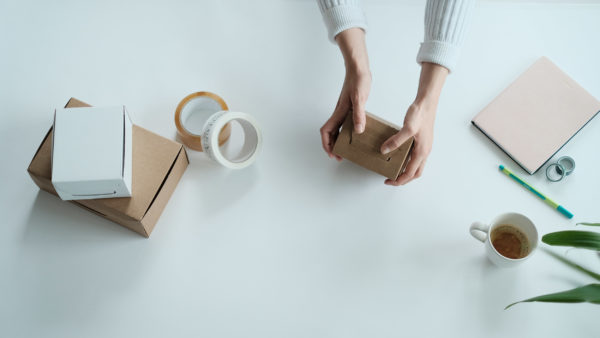 woman using self folding brown ecommerce mailing box