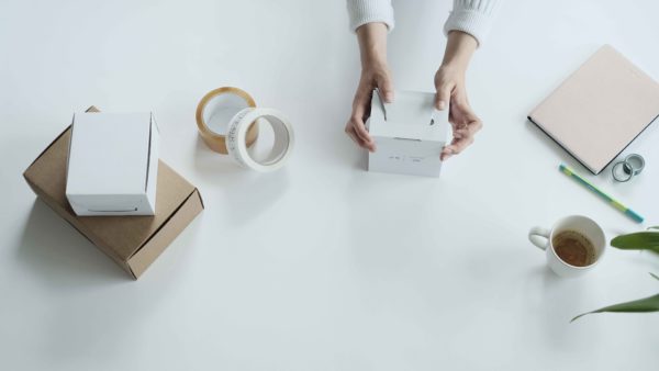 woman using self folding white ecommerce mailing box